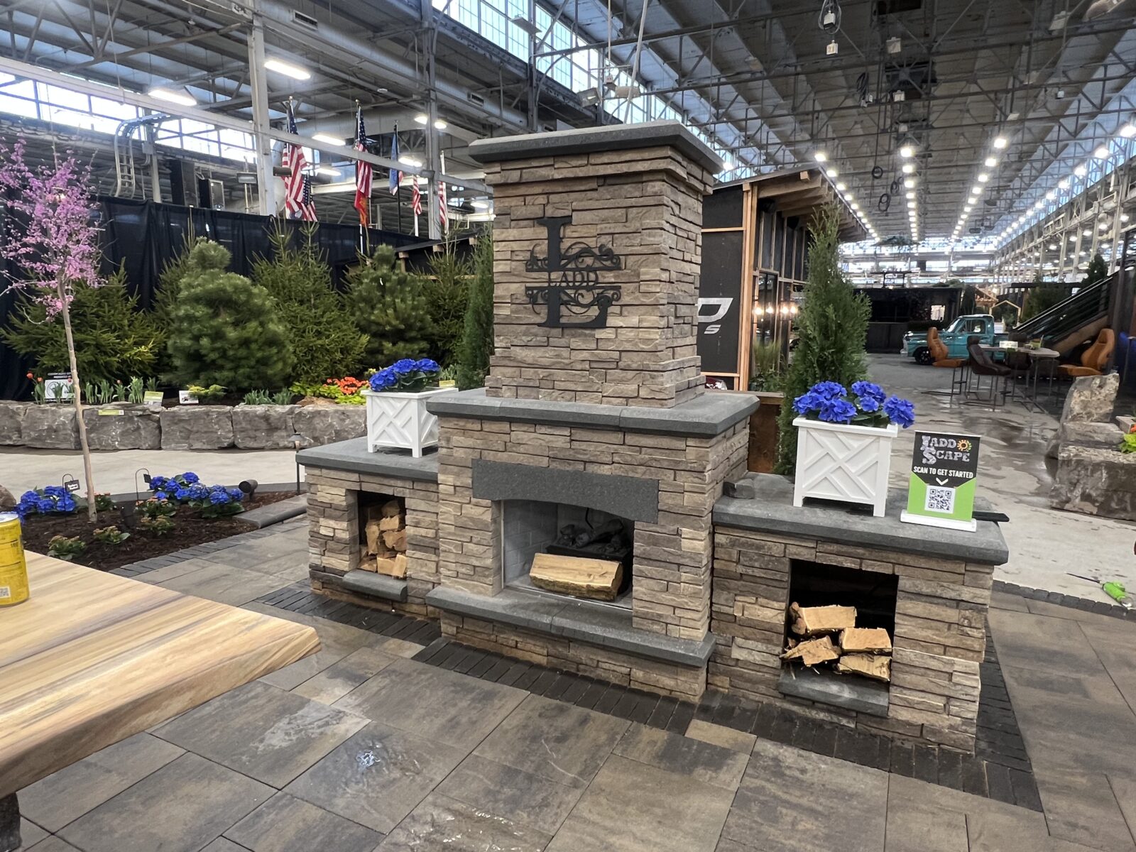 A unique fireplace display designed by Ladd Scape for the 2023 Indianapolis Home and Garden Show, featuring the company logo